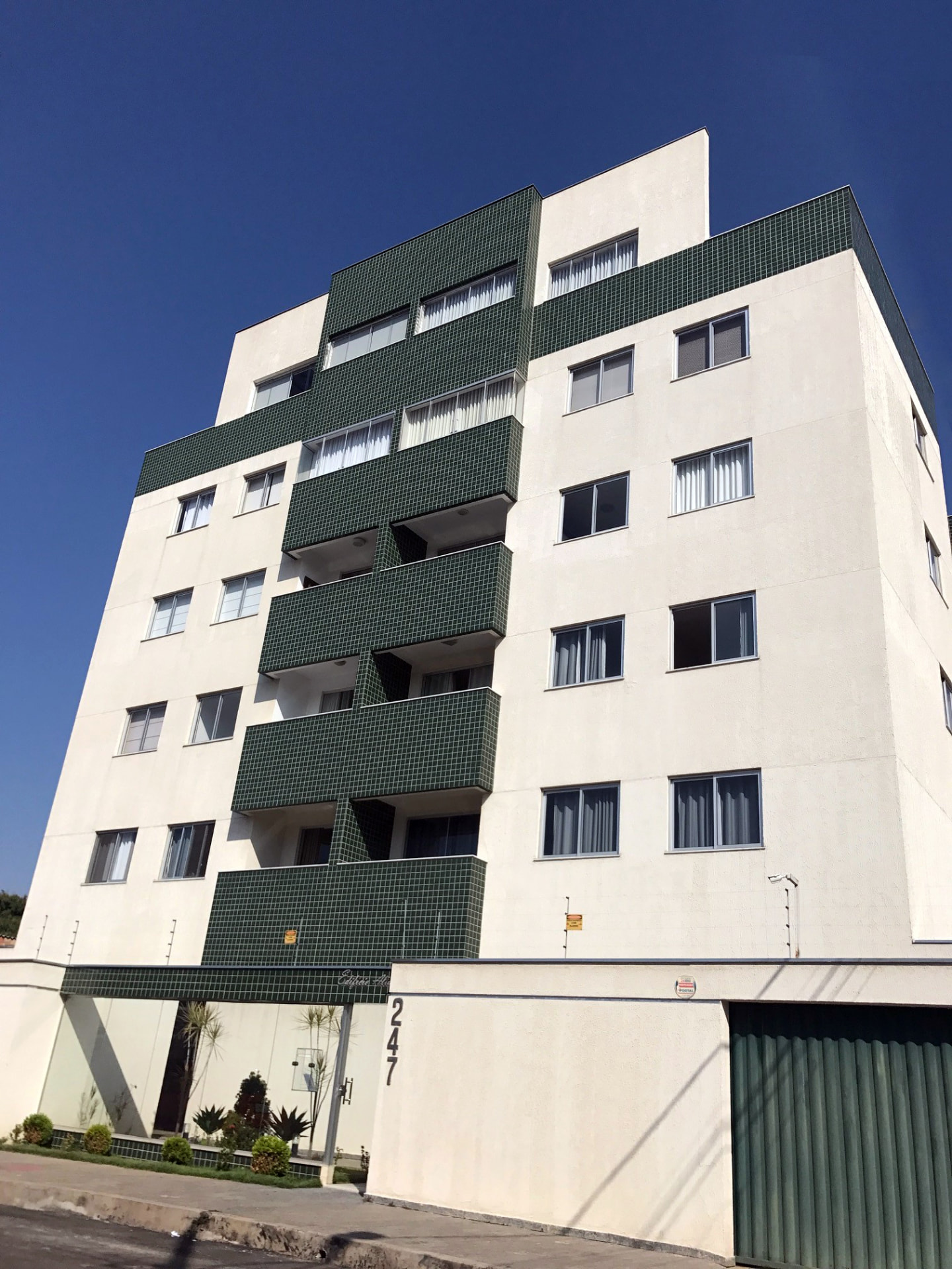 Fachada branca do Edifício Alta Vista com varandas em pastilha verde