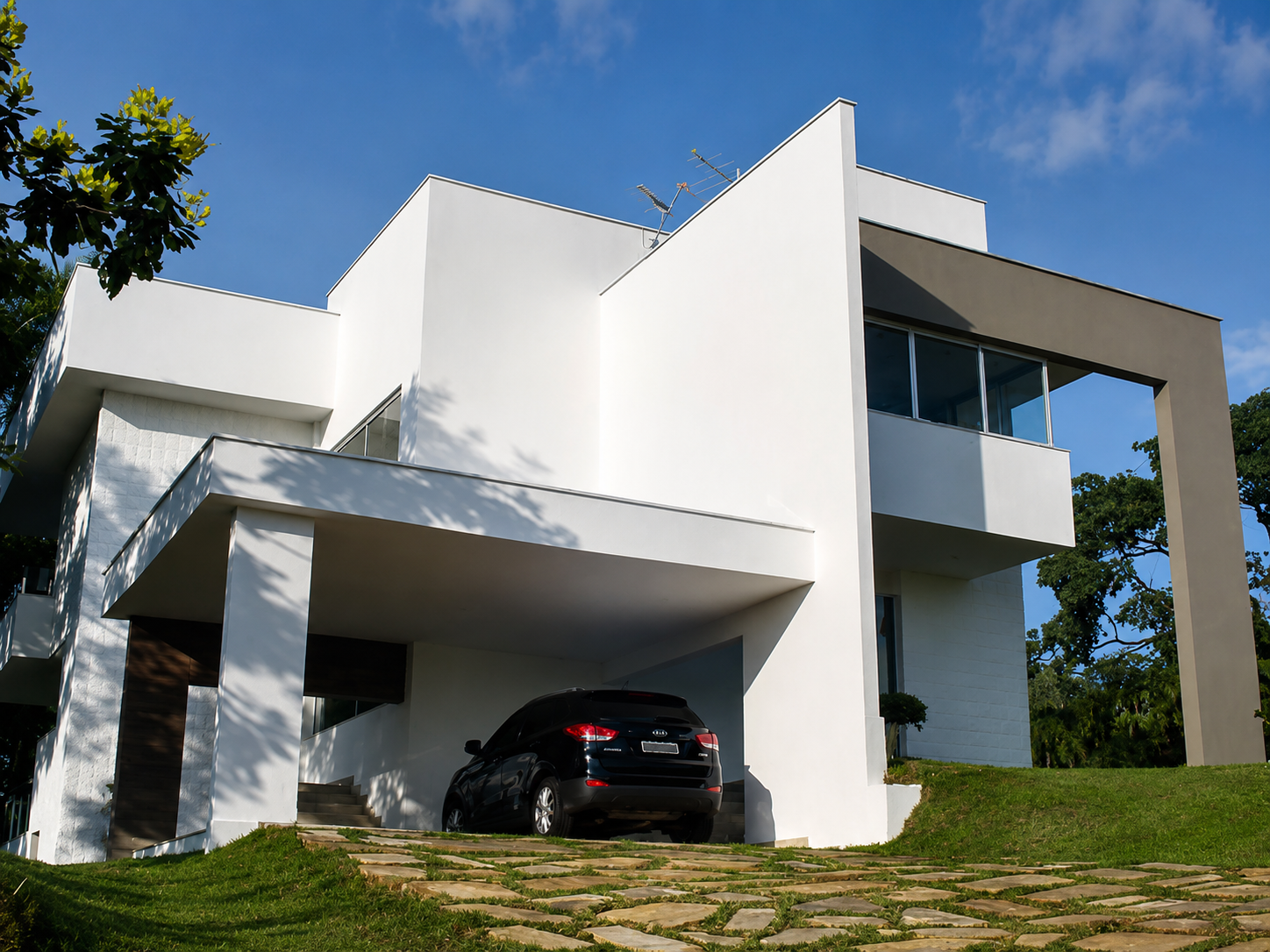 Casa de alto padrão branca com volumes geométricos, varanda envidraçada e garagem coberta
