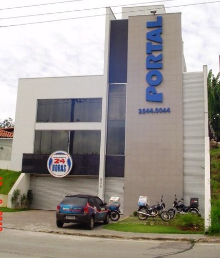 Edifício Portal com fachada cinza e letreiro azul em relevo