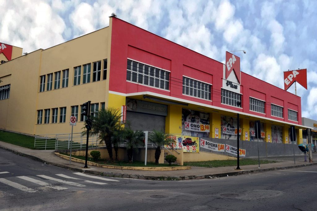 Fachada em vermelho e amarelo do supermercado EPA Plus em esquina
