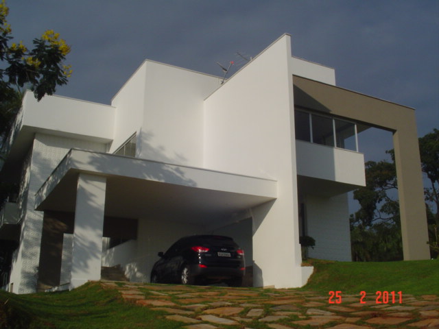 Fachada branca em volumes geométricos da residência Joelma