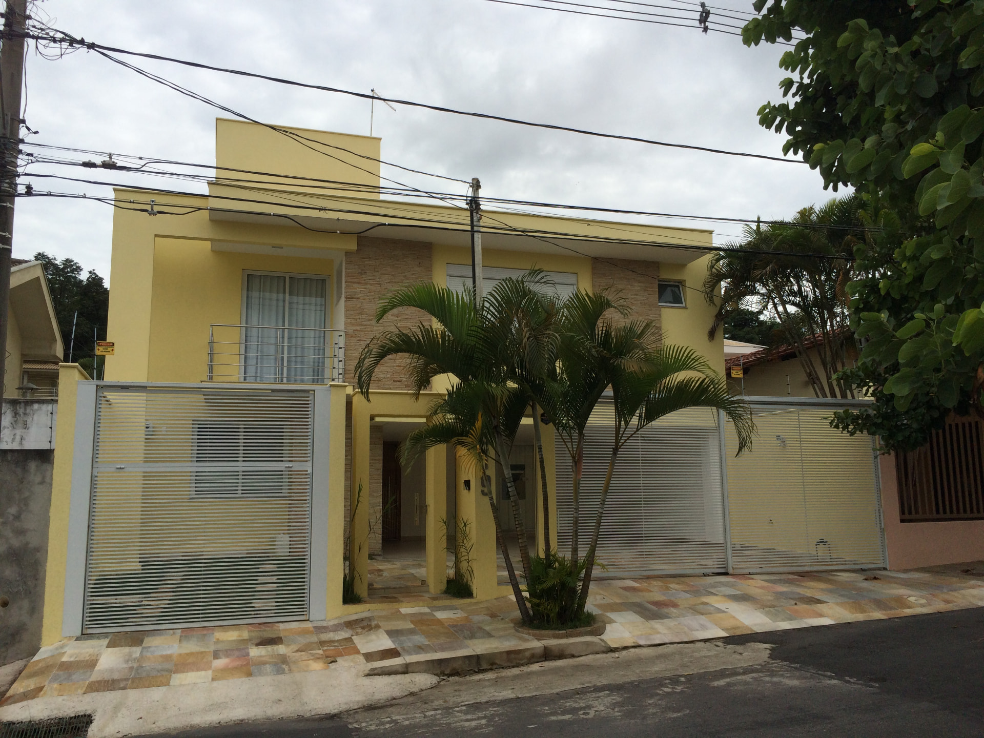 Sobrado amarelo com detalhes em pedra da residência Mário Lúcio
