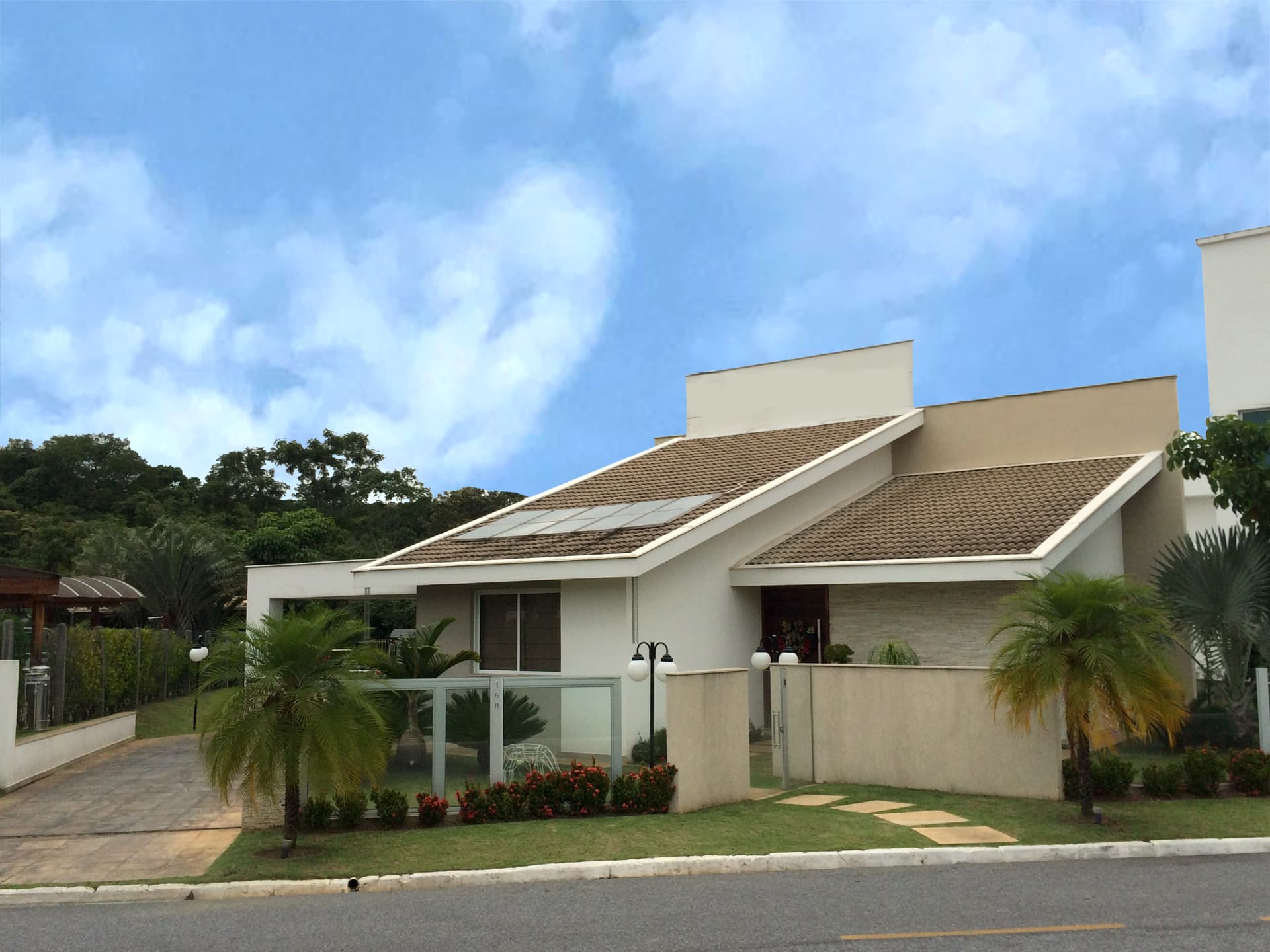 Casa térrea com telhado inclinado e paisagismo da residência Wagner